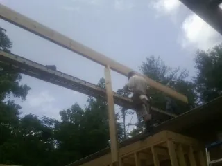 Carpenter setting a ridge beam over a new addition frame — Ice Dam Removal by Roofing Brothers in Moosic