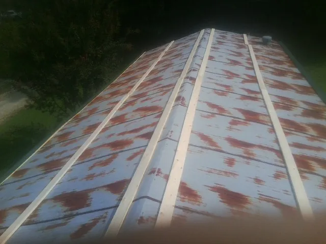 Rusted metal roof panels with new wood purlins before replacement — Storm Damage Roof Repair in Moosic by Roofing Brothers