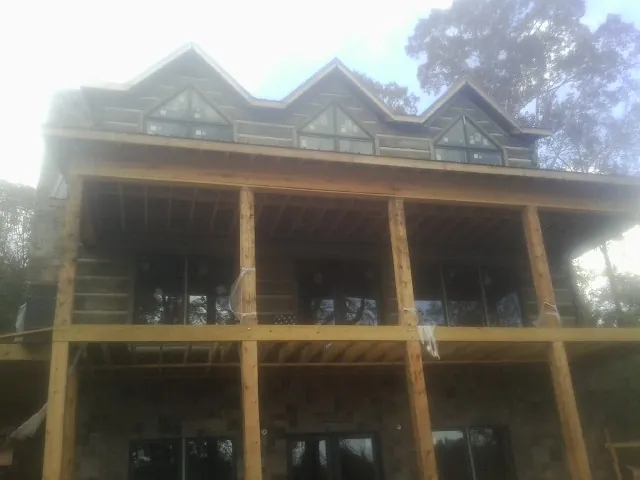 Dormers and porch framing on a large log home under construction — Roof Coating work by our crew in Moosic