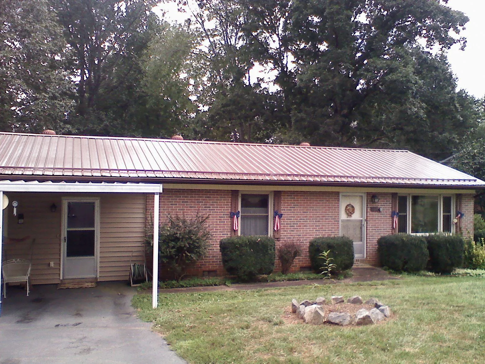 Bronze metal roof and carport on a brick ranch home — Roof Repair work by our crew in Moosic